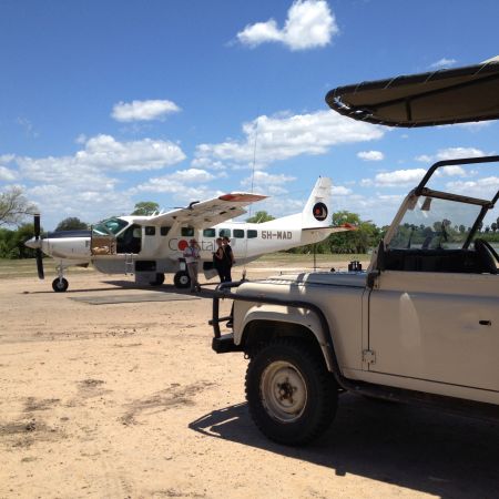 Fly-in safari plane being met by game vehicle, East Africa.